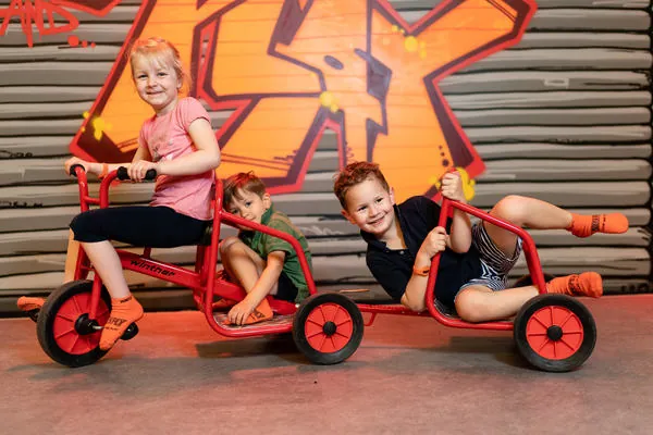 Kinder mit Tretfahrzeugen im Motorik Spielplatz